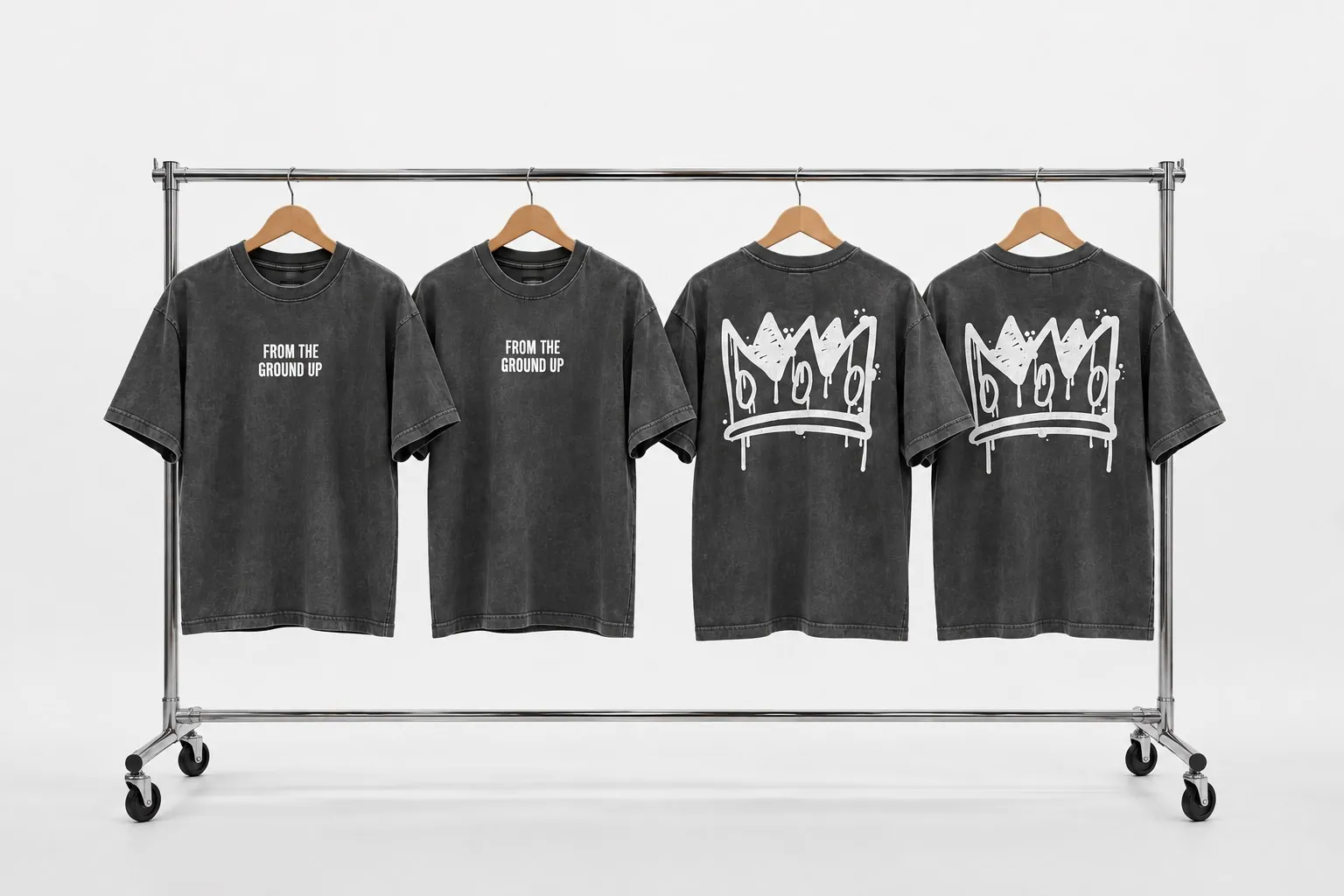Four washed black NBT Media 'From the Ground Up' tees on a chrome studio rack.